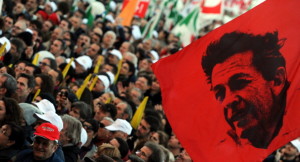 A demonstrator holds flag with a portrai